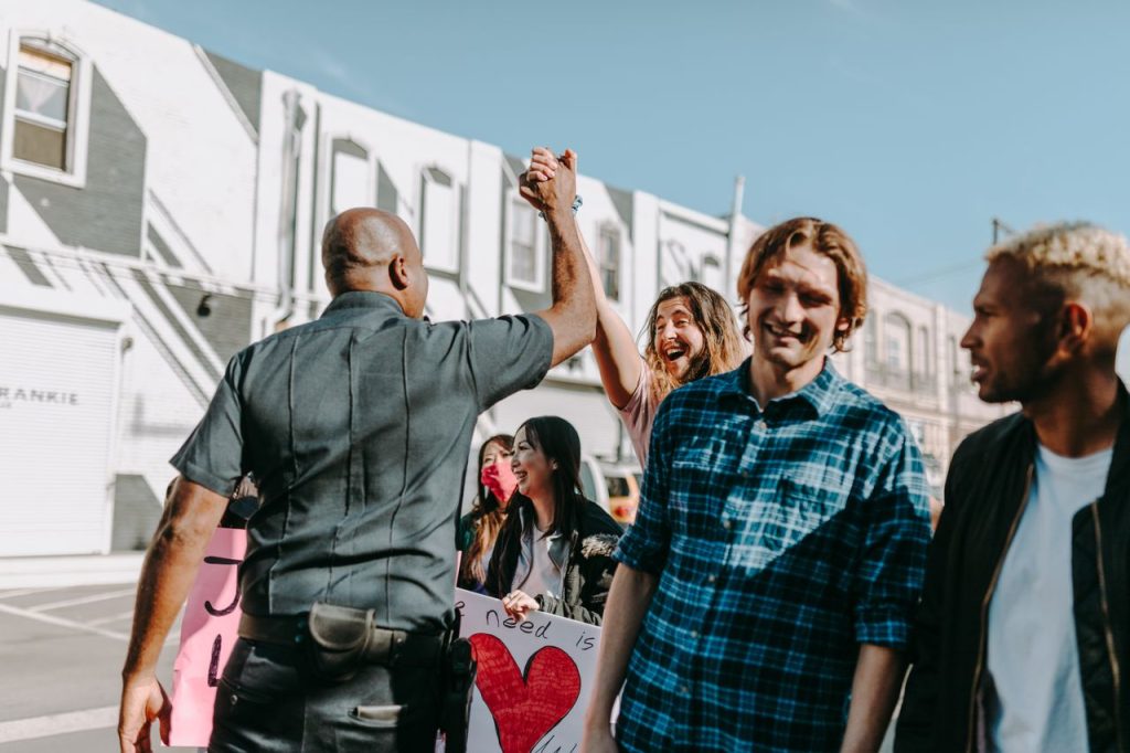 A joyful moment during a protest as a police officer and a protester share a high five.